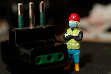 Miniature people construction worker wearing a safety mask and working on the site.