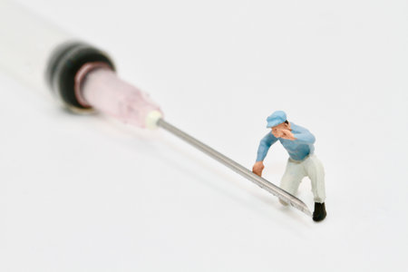 Miniature people : Worker repairing a syringe on white background.の写真素材