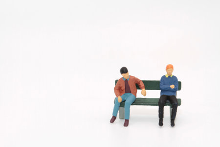 Miniature people sitting on bench. Image use for business concept.