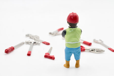 Miniature people engineer with wrench and screwdriver on white background.の写真素材