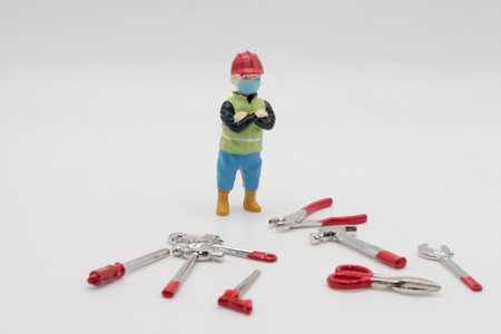 Miniature people construction worker and tools on white background with copy spaceの写真素材