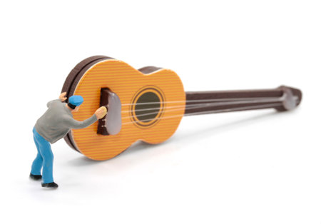 Miniature people : Musician playing acoustic guitar on white background.の写真素材