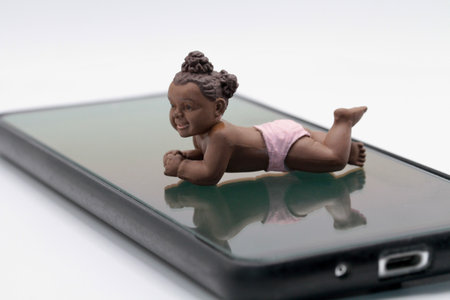 Miniature figurine of a girl lying on a mobile phone.