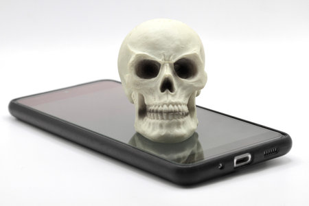 Smartphone with skull on the screen isolated on a white background.の写真素材