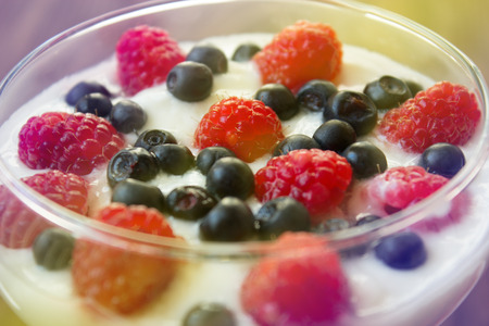 yogurt dessert with raspberries and blueberries in glassの写真素材