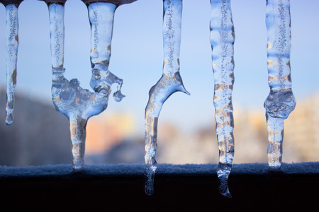 Dripping icicles against the sky. transparent icicle close up against the sky. Icicles on blue backgroundの写真素材