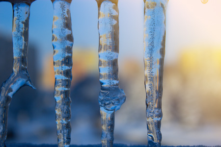 Dripping icicles against the sky. transparent icicle close up against the sky. Icicles on blue...
