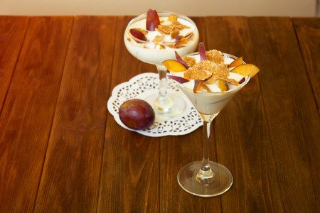 Healthy layered dessert with muesli  on table. yogurt dessert with plums and wheat flakes.の写真素材