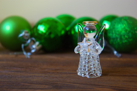 christmas balls on a wooden table.Crystal Angel on the background of  green Christmas balls,new Year decorationの写真素材