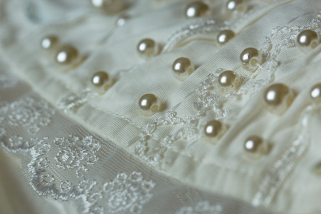 textile wedding background with beads. Tiny pearls embroidered over a wedding dressの写真素材