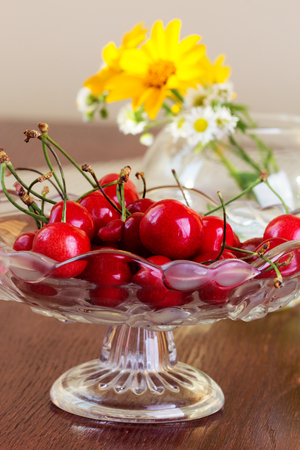 Cherries in a glass bowl on a wooden table. Ripe juicy red cherryの写真素材
