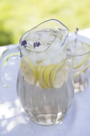 Lavender lemonade. Lavender lemonade in glass jug. Lemonade with lemons and lavender の写真素材