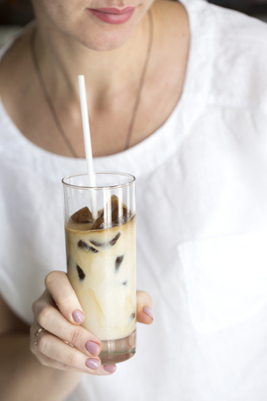 coffee ice in glass. Iced coffee cocktail or frappe with ice cubes and creamの写真素材