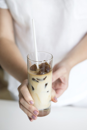 coffee ice in glass. Iced coffee cocktail or frappe with ice cubes and creamの写真素材