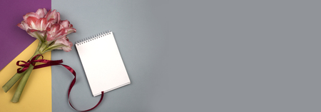 top view bouquet of spring flowers and notebook. Open blank notepad and bouquet of pink  flowers on table top view in flat lay style. Female desk topの写真素材