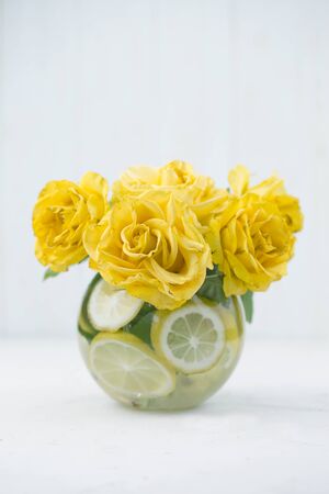 yellow rose in a glass vase. Yellow roses in vase on the table. Holidays and celebration conceptの写真素材
