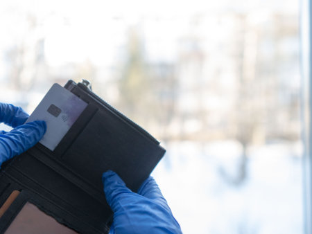 Holding the credit card in his hand, he pulled it out of his wallet. For business, shopping, and finance, the hand takes a payment card from a wallet with space for text.の写真素材