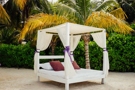 Balinese bed in the Caribbean sea under a wonderful tropical climate, ideal for summer vacation relaxation under the typical and exotic tropical vegetation ideal for relaxation and happiness.の写真素材