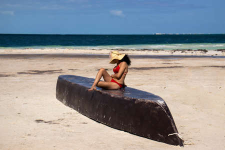 sexy woman sunbathing in bikini on a boat on a caribbean beach, the best to enjoy the summer, the sun, the sea and the ocean.の写真素材