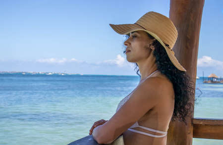 Sexy woman on the beach relaxed, happy and in harmony enjoying the calmness of the caribbean sea, both the sea and the ocean is an ideal place to enjoy the vacations.の写真素材