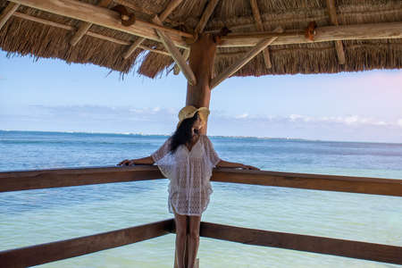 Sexy woman relaxing on the dock of a tropical turquoise Caribbean sea or ocean, this is a relaxing, romantic and ideal natural site for tourism and summer vacations.の写真素材