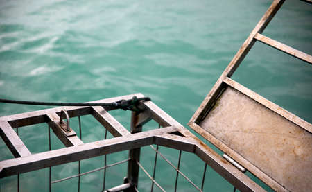 Shark observation cage ready to dive and with the door open at the shark alley in the Atlantic Ocean in Gansbaai (South Africa) these waters are teeming with marine life and white sharks.の写真素材