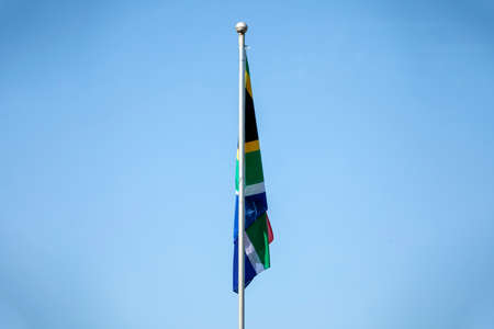 South African flag of the rainbow nation raised to the beautiful African sky, this country is located in southern Africa.の写真素材