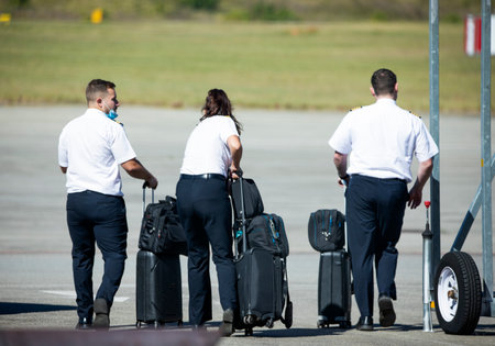 Three pilots with their bags and luggage heading down the runway to the aircraft to take off, they are aviation professionals from the rainbow nation also known as South Africa.のeditorial素材