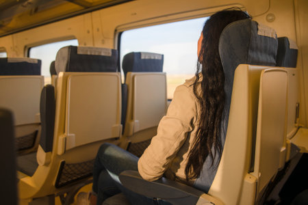 A beautiful hipster traveling on the train. Sitting on the comfortable train seat in Europe. Tourist...