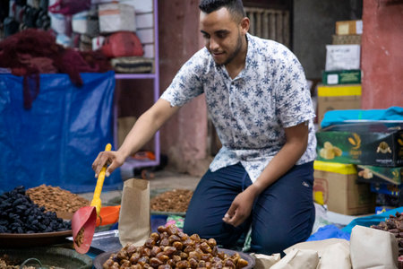 Beni Mellal, Morocco - October 10, 2022: Moroccan street vendor in the city of Beni Mellal which is in the center of the country, this street vendor sells all kinds of dried fruits like dates, etc.のeditorial素材