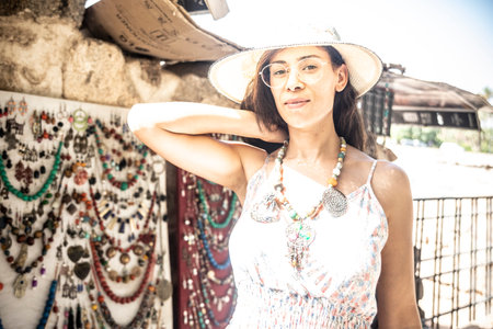 Beautiful young tourist woman trying on necklaces, bracelets and other jewelry in Marrakech is a former imperial city in western Morocco.の写真素材