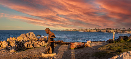 Beautiful panoramic view at sunrise with the statue of the famous Angus Taylor on the waterfront of the South African city of Hermanus, one of the southern city of Africa and ideal for whale watching.のeditorial素材