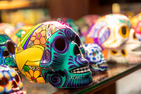 Xcaret, Mexico - November 22, 2022: Colorfully painted clay skulls on a shelf. A clay skull is a...