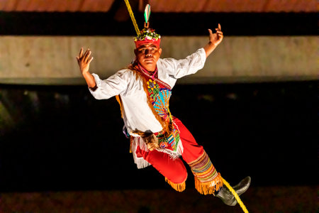Xcaret, Mexico - January 23, 2023: Flyer of papantla descending from the rope of the Xcaret park show in the middle of the tropical jungle of the Mayan Riviera, this is a Mesoamerican culture rite.のeditorial素材