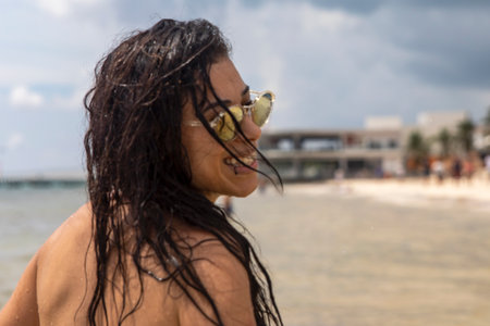 Young woman with sexy smile enjoying the Caribbean Sea on the white sandy beach of Playa del Carmen in the famous Mayan Riviera of Mexico, an ideal sun and beach vacation spot.の写真素材