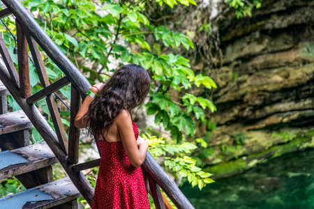Tourist in the stairway of the subway cenote Saamal of chichÃ©n itzÃ¡ is in the Mayan jungle hacienda of the Yucatan Peninsula in Mexico, it is an ideal place for vacation.の写真素材