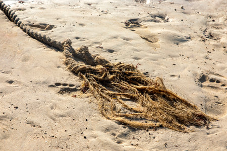 Seaworthy rope rope untied in the sand of the beach after being used in the marina to tie or launch any boat. Marine concept.の写真素材