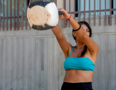 Sexy female athletes doing squats with the bulgarian bag or crossfit medicine ball, this is a fitness sport that requires cardio. Sports concept.の写真素材