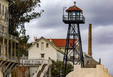 Barracks and guardhouse with its watchtower of the federal prison of Alcatraz Island of the United States in the bay of San Francisco, California, USA. Surveillance under a cloudy sky. Jail concept.の写真素材