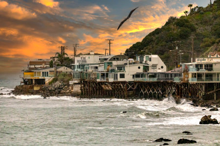 Houses on the Pacific Ocean and an orange sky at sunset in the Californian town of Malibu, a few kilometers from Los Angeles in the state of California in the United States of America.の写真素材