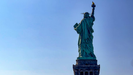 The famous Statue of Liberty of the Big Apple and Manhattan seen from the back, a monument known as the lady of New York all over the world.の写真素材