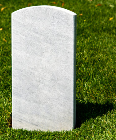 Vertical photo of a white tombstone on a grassy lawn at Arlington National Cemetery, a military cemetery in Washington DC, the capital of the USA.の写真素材