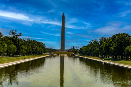 The obelisk of President George Washington under a blue summer sky on the National Mall in...