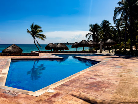 Panoramic view of a beautiful pool of a luxurious white sandy beach resort, with the turquoise and crystal clear sea of the Caribbean Sea in Mexico.の写真素材
