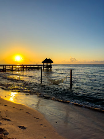 Sunrise Paradise: The enchanting beauty of the Caribbean sunrise. Watch as the sun paints the sky with hues of gold and orange, illuminating the soft white sand and crystal-clear waters.の写真素材