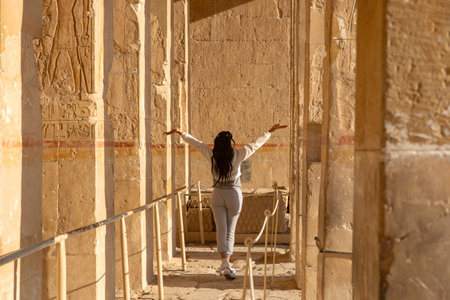 Watch as a traveler's dream comes true at Hatshepsut's temple. Surrounded by ancient ruins, she experiences the magic of ancient Egypt.の写真素材