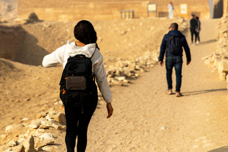 Witness a tourist exploring Egypt's enigmatic ruins, venturing into ancient tombs and pyramids. Experience the mystery and wonder of this historic landscape.の写真素材
