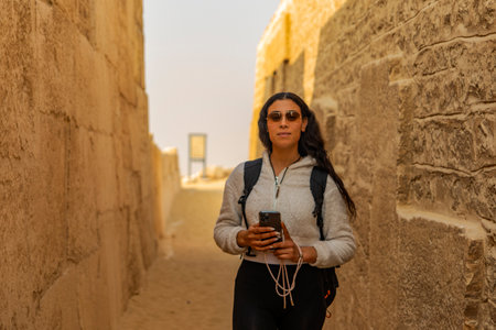 See a tourist woman enjoying Saqqara, the Memphis Necropolis on the West Nile, Egypt. Explore the ancient wonders and historical significance of this site.の写真素材