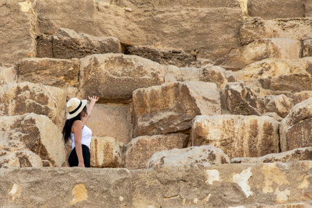 Witness the majestic pyramid of Giza as a tourist explores Cheops, a modern world wonder. Discover the ancient history and architectural significance.の写真素材