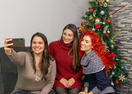 Women taking a selfie with the cell phone at christmasの写真素材